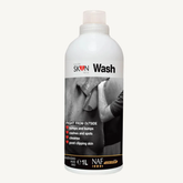 A 1-liter white bottle of Skin Wash by NAF, featuring a black and white label with a photo of a person shaving and text detailing its benefits, set against a plain off-white background.