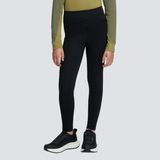 Child wearing black trousers and a green base layer agaisnt a white background.
