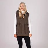 Woman wearing a brown gilet over a white shirt on a light grey background