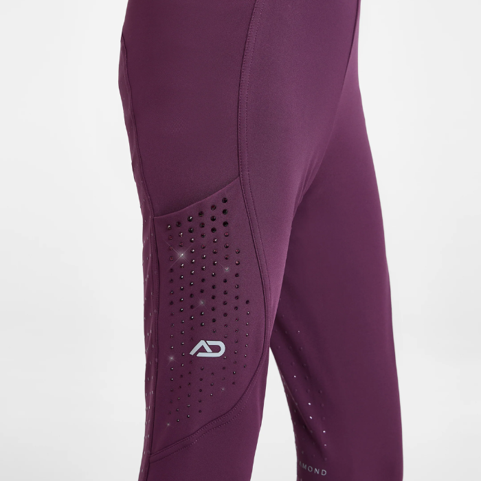 Close-up of a pair of athletic leggings in a deep plum purple color, featuring a perforated knee panel with a white stylized 'AD' logo.