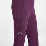 Close-up of a pair of athletic leggings in a deep plum purple color, featuring a perforated knee panel with a white stylized 'AD' logo.