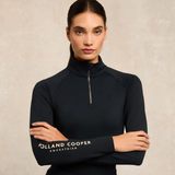 Woman wearing a black equestrian top with 'Holland Cooper' branding on a beige background