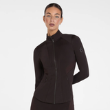 Aztec Diamond AW26 Core Fitted Jacket Variant Espresso. A woman modeling a dark brown full-zip athletic jacket with a mock neck and long sleeves, featuring a subtle logo on the left sleeve, against a plain white studio background.