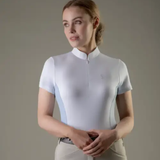 Woman wearing a white short-sleeve shirt against a plain background