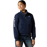 Ariat Youth 2.0 Insulated Stable Jacket Varient Navy. Girl wearing navy jacket with Ariat branding down the sleeve on a white background.