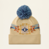 Ariat Ladies Serape Beanie Varient Natural Serape. Beige hat with a multicolour graphic and a blue pom pom on a light background.