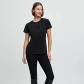 Woman wearing a black t-shirt and leggings on a light gray background