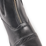 Close-up of a black leather boot with a gold zipper on a white background