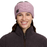 Woman wearing a pink headband with brown logo against a white background.