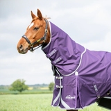 A purple horse turnout rug with white trim and branding, shown on a brown horse in an outdoor field under a cloudy sky.