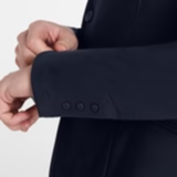 Close-up of a person adjusting the cuff of a dark suit jacket on a light gray background