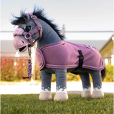 Toy pony with pink accessories on grass background