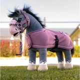 Toy pony with pink accessories on grass background
