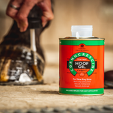 Cornucrescent Hoof Oil can with a horse hoof in the background