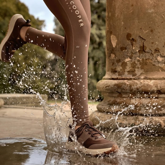Person running through water with brown leggings and matching trainers