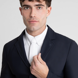Man wearing a dark suit jacket over a white shirt on a light gray background