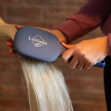 Person using a brush 'LeMieux' on a faded background