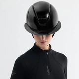 Person wearing a black equestrian helmet and matching outfit with 'LeMieux' branding on a light gray background.