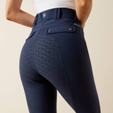 Close-up rear view of a person wearing navy equestrian riding breeches with a subtle tonal geometric pattern on the seat area, shown against a light beige studio background.