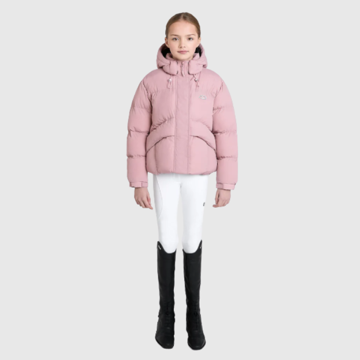 Person wearing a pink puffer jacket, white trousers, and black boots on a light grey background