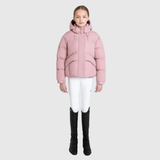 Person wearing a pink puffer jacket, white trousers, and black boots on a light grey background