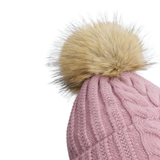 Close up of a pink beanie with a beige pompom against a white background.