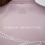 Pikeur AW26 Zip Print Shirt Collection Variant Ash Mauve. Close-up back view of a light pink athletic top with white dotted graphic lines and the text 'PIKEUR SELECTION' printed across the center, plus a small brand patch near the neckline.