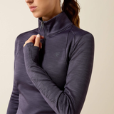 Ariat Ladies Team EQ 1/2 Zip Pullover Variant Odyssey Grey. A close-up of a woman wearing a dark purple long-sleeve athletic quarter-zip top, showing the zipper, textured fabric, and a subtle embroidered logo on the chest.
