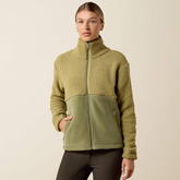 Ariat Ladies Laviolette Full Zip Jacket Variant Oil Green. A woman modeling a fleece zip-up jacket with a colorblock design, featuring a textured khaki upper section and a solid olive green lower panel, set against a plain beige background.
