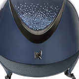 Close up of a navy riding hat with glitter on the front of the panel on a white background.