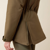 Back of a khaki jacket with side zips against a beige background.