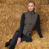 Women on bales of straw wearing Khaki green gillet over black long sleeve top and leggings