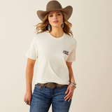 Woman wearing a light t-shirt with ariat brand logo, blue jeans, and a brown western hat on a beige background