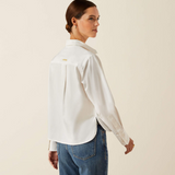 Woman wearing a white shirt and blue jeans on a beige background