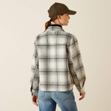Person wearing a plaid shirt and cap on a beige background