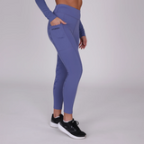 Person wearing blue riding leggings with phone pocket and Aubrion logo