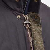 Close-up of a jacket with a zipper and Barbour logo on a gray background