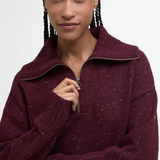 Person wearing a burgundy jumper with a zipper on a white background