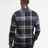 Man wearing a tartan shirt with a grey background