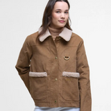 Woman wearing a brown Barbour jacket with shearling trim on a white background
