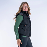 Woman wearing a black gilet and green base layer with 'Blackfort' branding on a white background