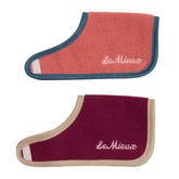 Two fleece horse rugs by LeMieux on a white background, one in coral pink with teal trim and one in burgundy with beige trim.