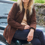 Woman sits on Land Rover wearing the Dubarry Ladies Clarke Leather Jacket in Walnut