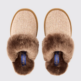 Pair of brown slippers with fur trim on a light grey background