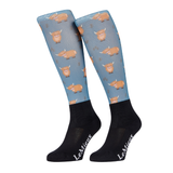LeMieux AW26 Footsie Socks Highland Cow Vairant Colour Aloe.
A pair of LeMieux knee-high socks featuring a light blue upper leg section with a repeating pattern of brown highland cows, and solid black lower legs with white LeMieux branding.