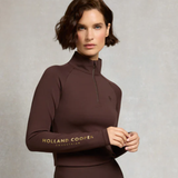 Woman wearing a brown quarter-zip base layer with 'Holland Cooper' branding on a neutral background
