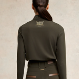 Person wearing an olive green equestrian base layer with Holland Cooper logo on the back against a neutral background