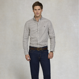 Man wearing a checkered shirt and dark jeans against a plain background