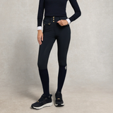 Person wearing black riding tights with a logo on a neutral background