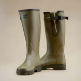 Pair of green rubber boots on a beige background